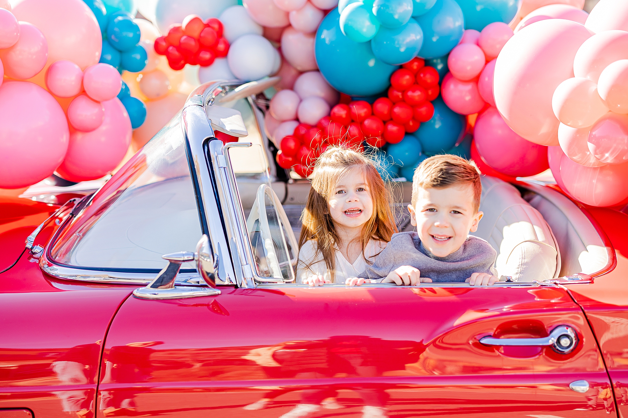 kids play in front seat of red Thunderbird at Sips and Dips