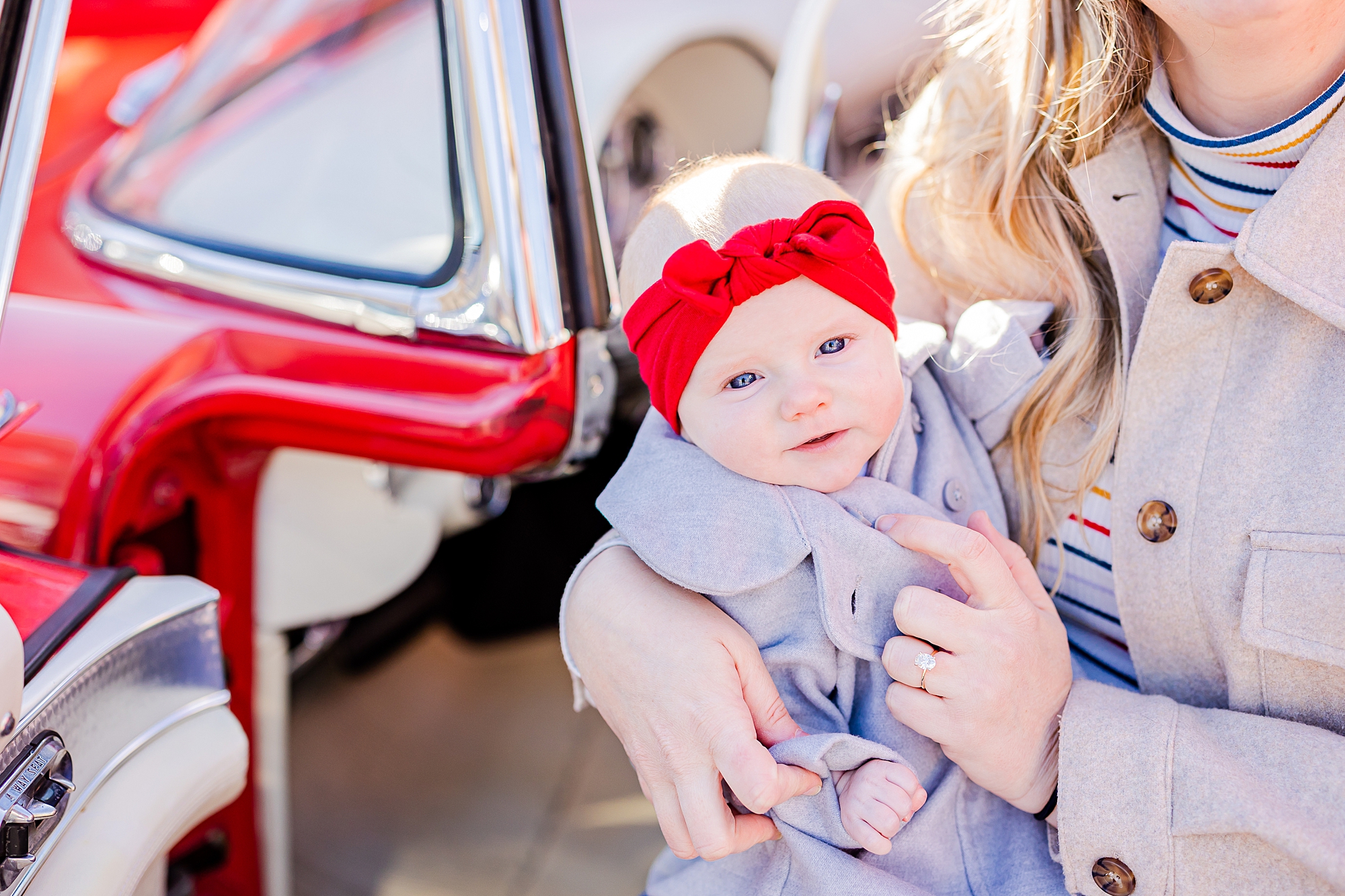 woman poses with baby with red headband inside thunderbird 