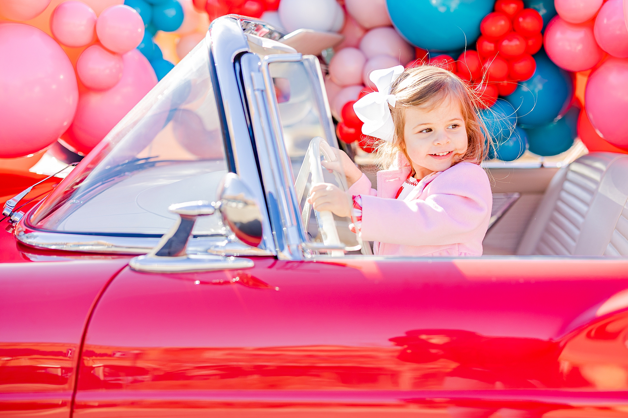 girl smiles holding steering wheel during Valentine’s Day Thunderbird Photos