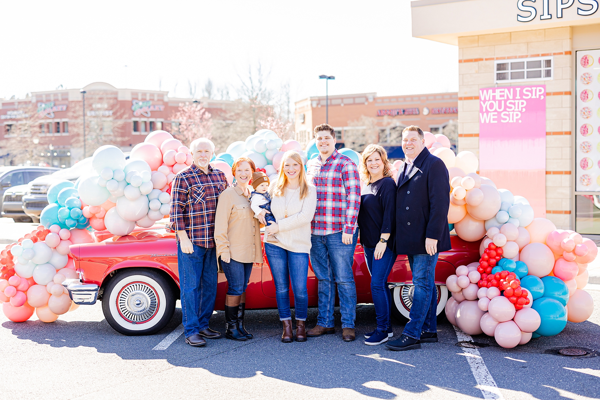family poses by red car during valentine's day photos 