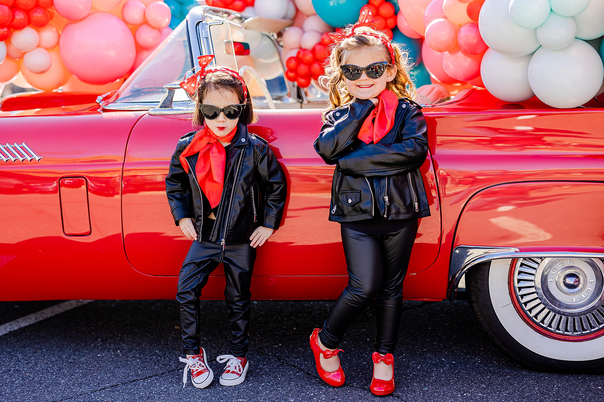 girls pose in leather jackets and black pants with red scarf during Valentine’s Day Thunderbird Photos